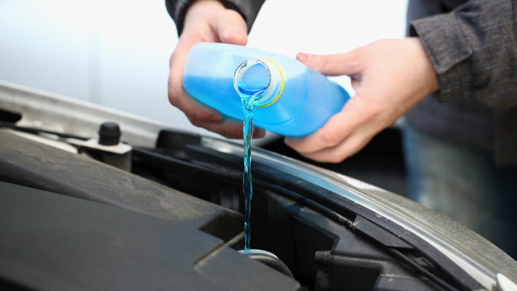 A mechanic performing a cooling system flush on a car, highlighting why understanding coolant flush cost matters.