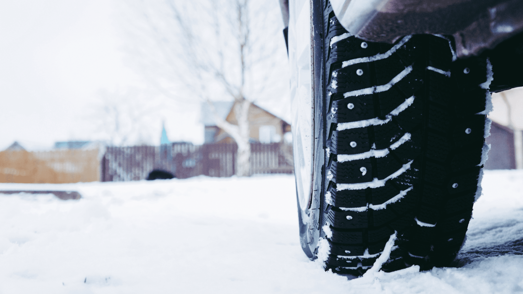 Car equipped with winter tires driving in snowy Northbrook road conditions