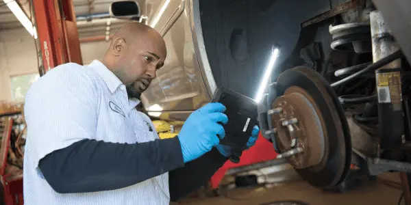 Close-up of professional rotor replacement during brake service