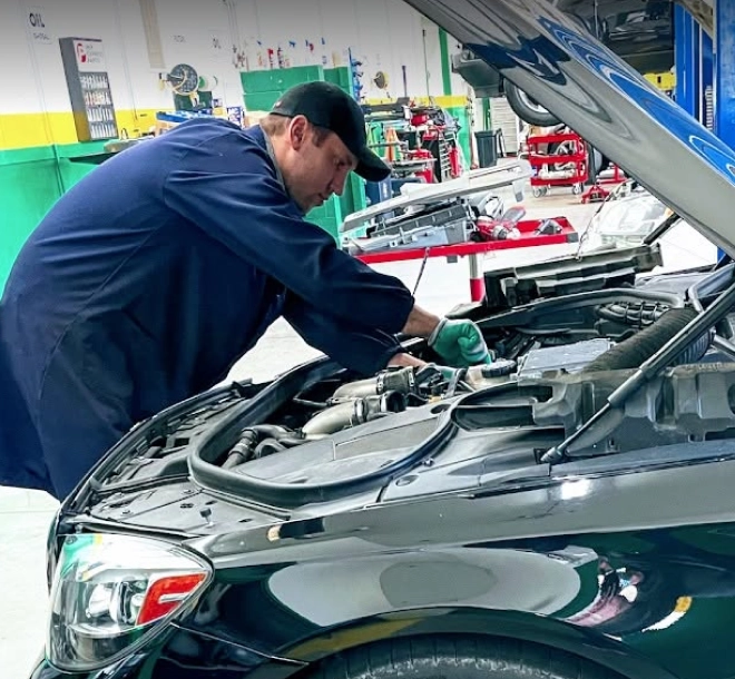 Technician servicing a vehicle engine