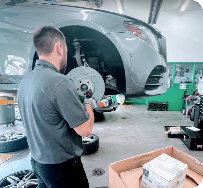 Technician inspecting a vehicle's brakes